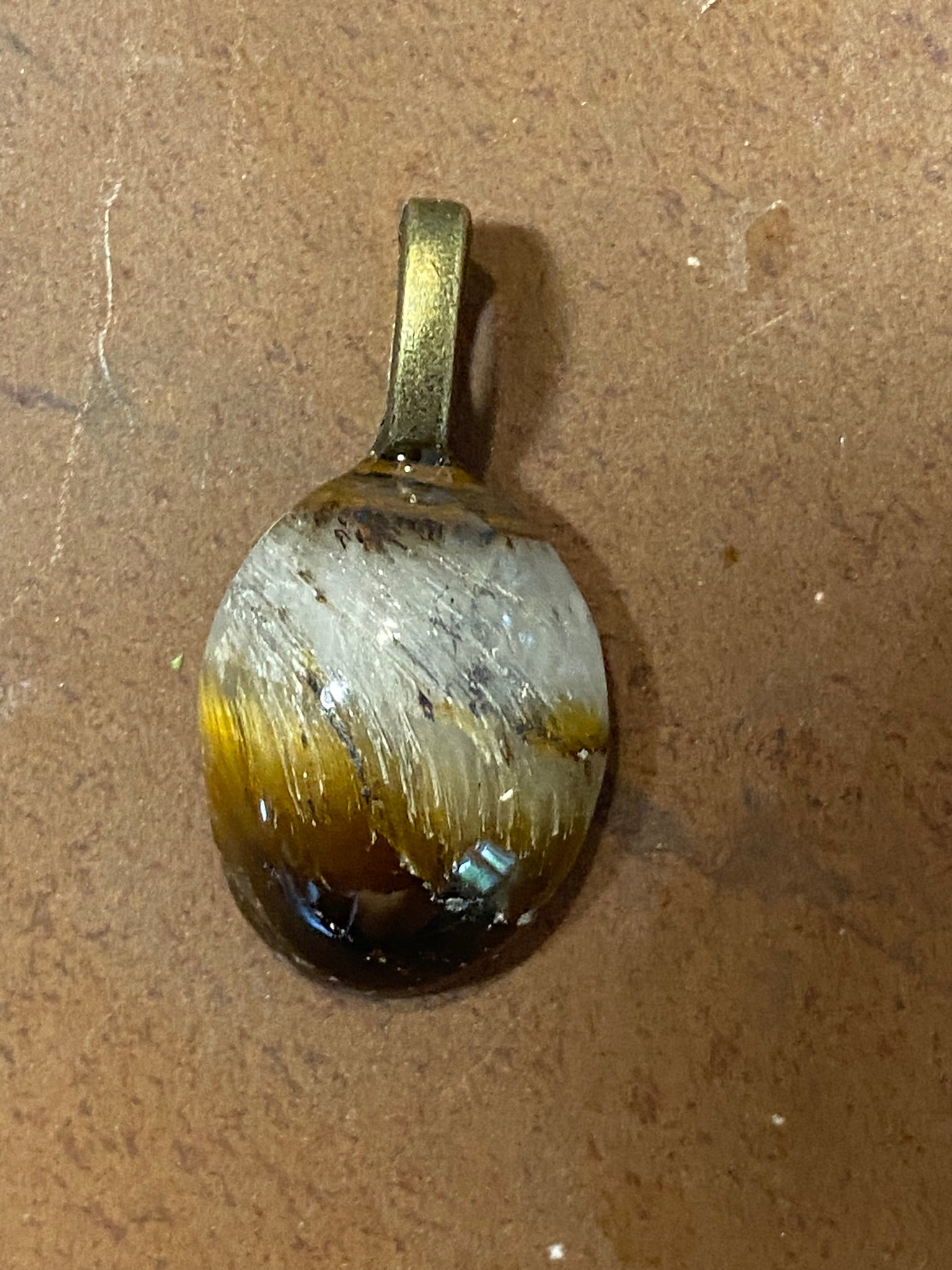 Pendant with a brown and white stone on a brown background