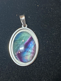 Multicolored Flourite stone pendant with silver frame on a black background
